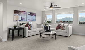 Carpeted living room with ceiling fan, plenty of natural light, and a mountain view