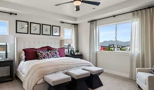 Carpeted bedroom featuring ceiling fan, a mountain view, and multiple windows