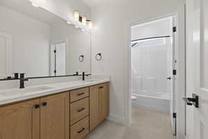 Full bathroom featuring shower / bath combination, vanity, tile patterned floors, and toilet