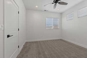 Empty room featuring ceiling fan and carpet