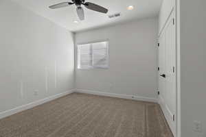 Carpeted spare room featuring ceiling fan