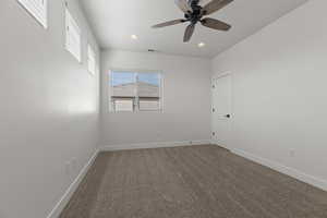 Carpeted empty room featuring ceiling fan