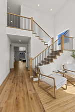 Stairway featuring hardwood / wood-style floors and a towering ceiling