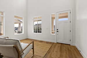 Entrance foyer featuring light hardwood / wood-style floors and a high ceiling