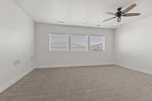 Spare room with ceiling fan and carpet flooring