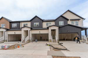 View of front facade with a garage, entry steps, and concrete driveway