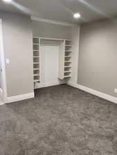 Unfurnished bedroom with dark carpet and a closet