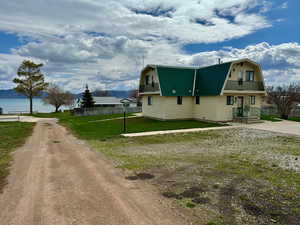 View of side of home featuring a water and mountain view.  Showing access to lake.