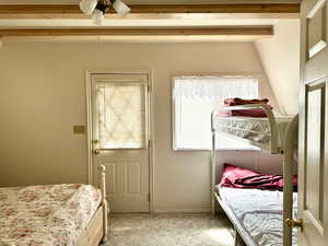 Bedroom featuring beamed ceiling and light colored carpet