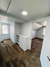 Bonus room featuring lofted ceiling and dark carpet