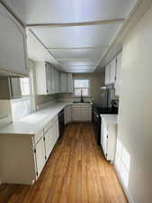 Kitchen with white cabinets, sink, and black appliances