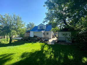 Back of house featuring an outbuilding and a lawn