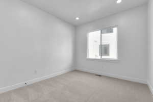 Spare room featuring visible vents, baseboards, recessed lighting, and light carpet