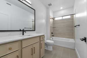 Full bath featuring shower / washtub combination, vanity, tile patterned flooring, visible vents, and toilet