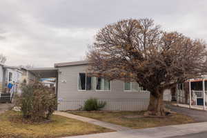 View of front of property featuring a front lawn and a carport