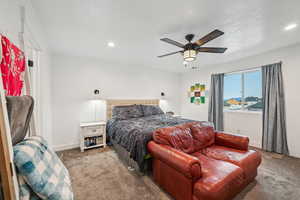 Bedroom featuring carpet flooring, a textured ceiling, and ceiling fan