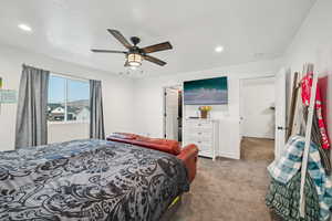 Bedroom featuring a spacious closet, carpet floors, and ceiling fan