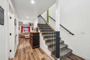 Staircase with ceiling fan and hardwood / wood-style floors