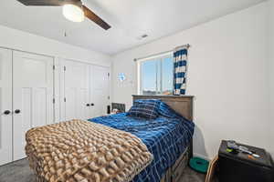 Carpeted bedroom featuring ceiling fan