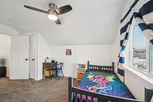 Carpeted bedroom featuring lofted ceiling and ceiling fan