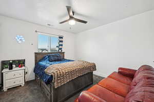 Bedroom with ceiling fan and dark carpet