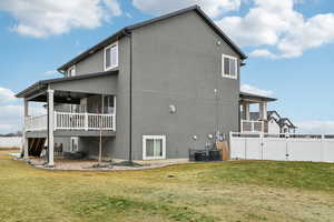 Back of property featuring a yard and central air condition unit