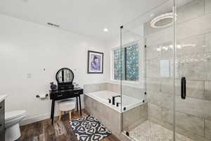 Full bathroom featuring hardwood / wood-style flooring, vanity, toilet, and separate shower and tub