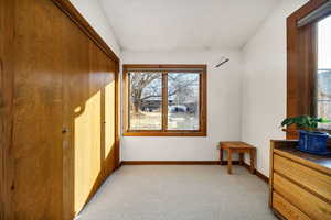 Empty room with lofted ceiling and light colored carpet