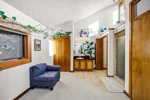 Sitting room featuring lofted ceiling and light tile patterned flooring