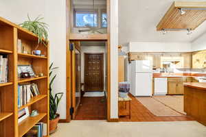 Kitchen with light carpet, sink, white appliances, and track lighting