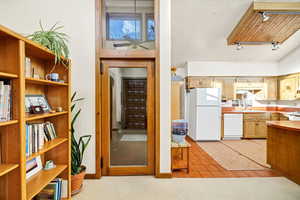 Kitchen with light carpet, sink, track lighting, and white appliances