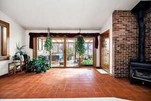 Unfurnished sunroom featuring a wood stove