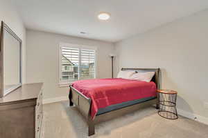Bedroom featuring light colored carpet