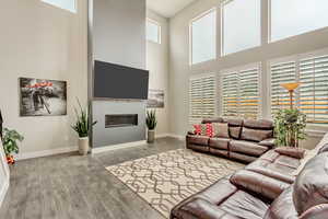Living room with a towering ceiling and light hardwood / wood-style flooring