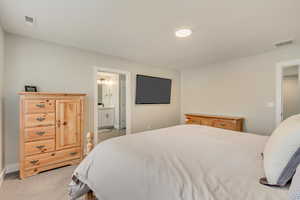Carpeted bedroom featuring connected bathroom