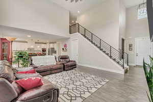 Living room with a towering ceiling and light hardwood / wood-style flooring
