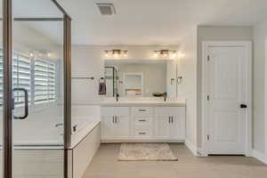Bathroom featuring vanity and shower with separate bathtub