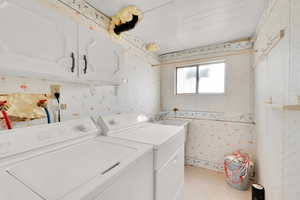 Laundry room featuring cabinets, sink, and washing machine and clothes dryer