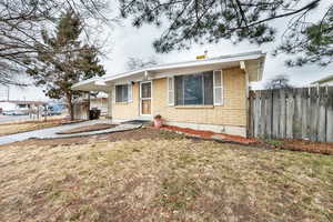 View of front of house featuring a carport and a front yard