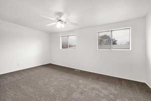 Empty room with ceiling fan and carpet flooring