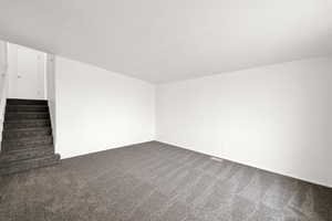 Carpeted empty room with vaulted ceiling