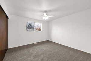 Spare room featuring carpet flooring and ceiling fan