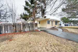 View of side of property with a carport and a lawn