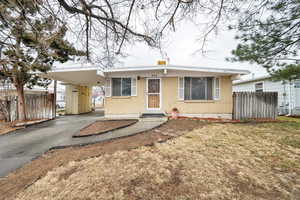 View of front of house featuring a carport and a front yard