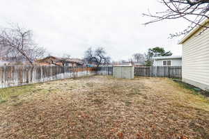 View of yard featuring a storage shed and a water view