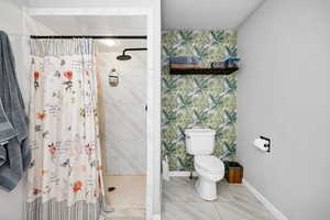 Bathroom with curtained shower, a textured ceiling, and toilet