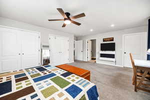 Unfurnished bedroom with multiple closets, ceiling fan, and carpet