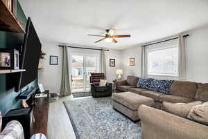 Living room with ceiling fan, light hardwood / wood-style flooring, and a textured ceiling