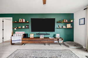 Living room with hardwood / wood-style floors and ceiling fan