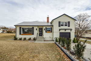 View of front of house with a garage and a front yard